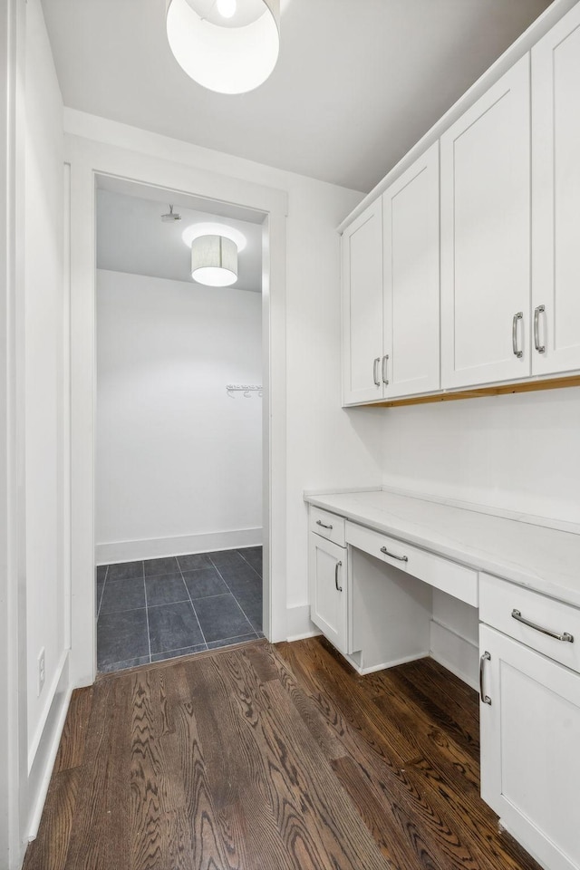 laundry area featuring dark wood-style floors and baseboards