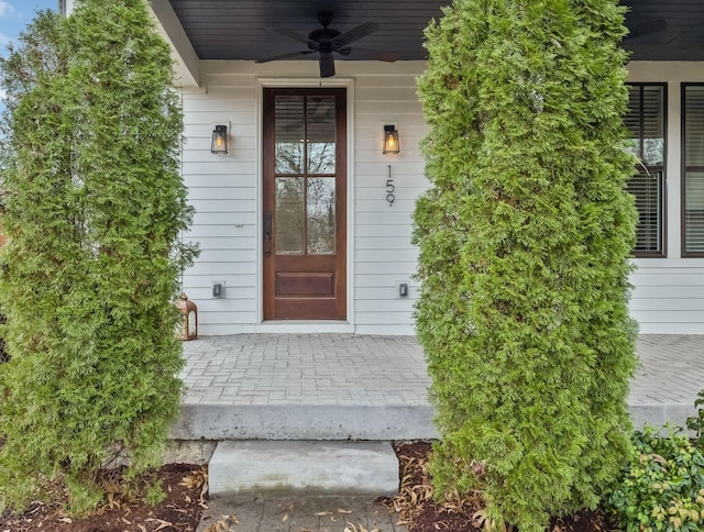 doorway to property with a porch and a ceiling fan