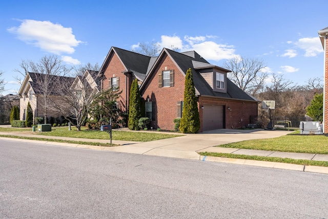 traditional-style house with a front lawn, brick siding, driveway, and an attached garage