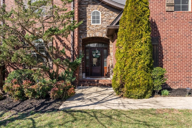 entrance to property with stone siding and brick siding