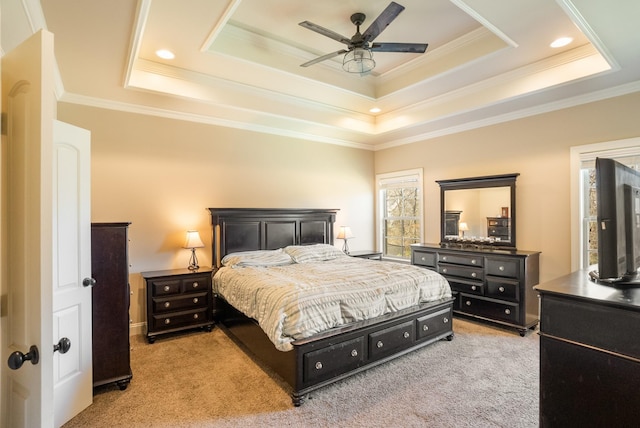 bedroom with a ceiling fan, a raised ceiling, light colored carpet, and crown molding