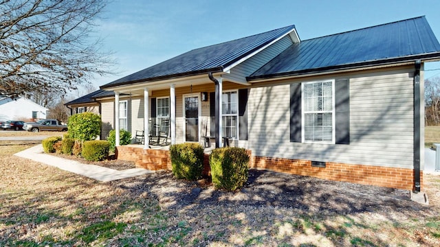 exterior space with covered porch, metal roof, and crawl space