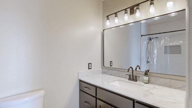 bathroom featuring curtained shower, vanity, and toilet