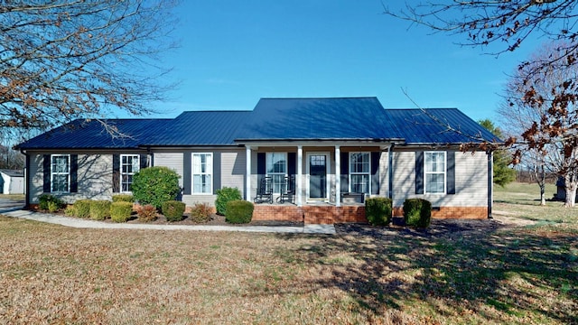 view of front of property featuring a porch, a front yard, and metal roof