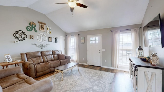 living area with ceiling fan, vaulted ceiling, baseboards, and wood finished floors