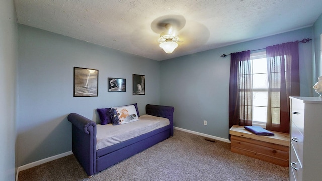 carpeted bedroom with multiple windows, visible vents, baseboards, and a textured ceiling