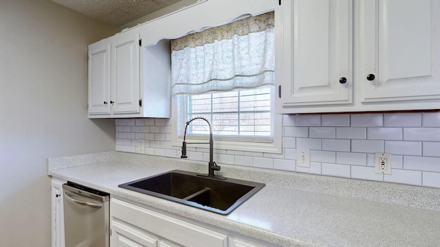 kitchen with dishwasher, light countertops, a sink, and white cabinets