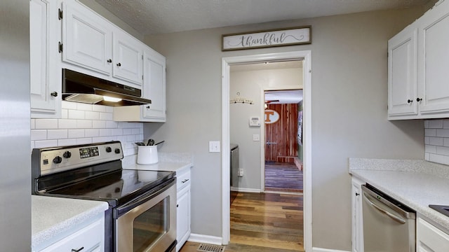 kitchen featuring stainless steel appliances, light countertops, white cabinetry, and under cabinet range hood