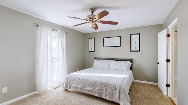 bedroom with carpet floors, a textured ceiling, baseboards, and a ceiling fan