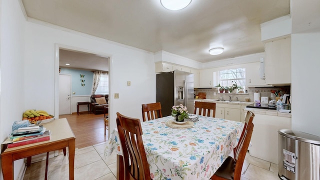 dining space featuring ornamental molding and light tile patterned flooring