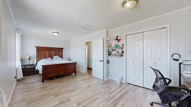 bedroom featuring crown molding, a closet, attic access, light wood-style floors, and baseboards