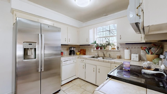 kitchen with decorative backsplash, light tile patterned flooring, a sink, dishwasher, and stainless steel fridge with ice dispenser