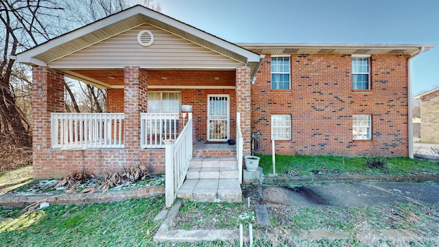 view of front facade with a porch and brick siding