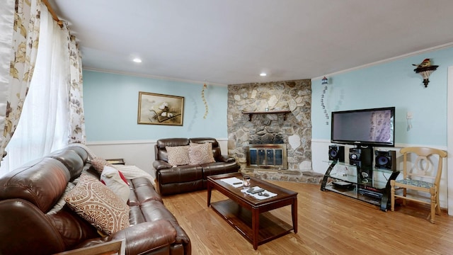 living area with crown molding, a fireplace, and wood finished floors