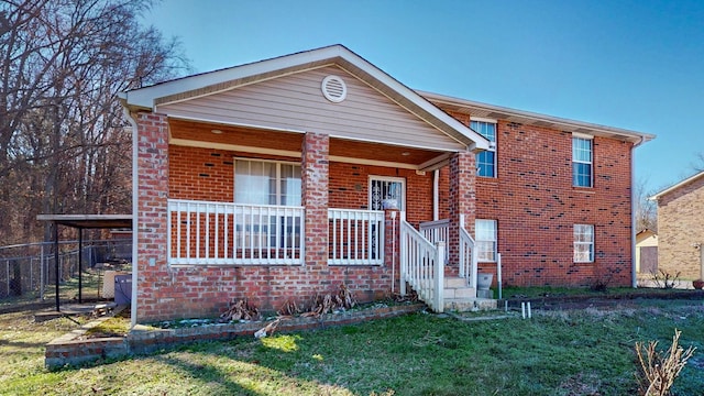 tri-level home with a front yard, a porch, and brick siding