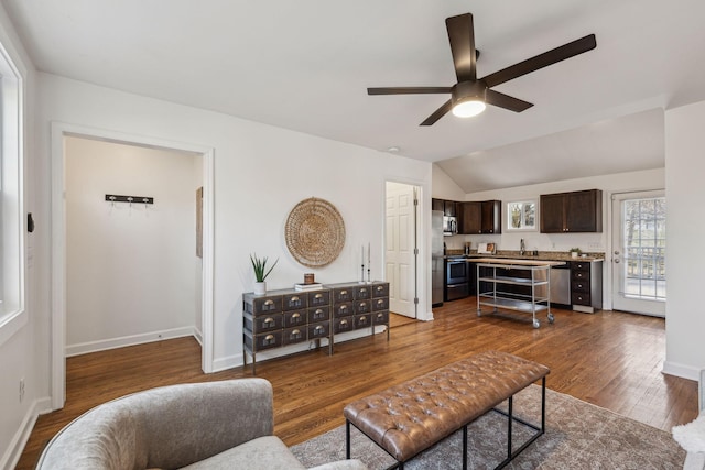 living room featuring a ceiling fan, lofted ceiling, baseboards, and wood finished floors