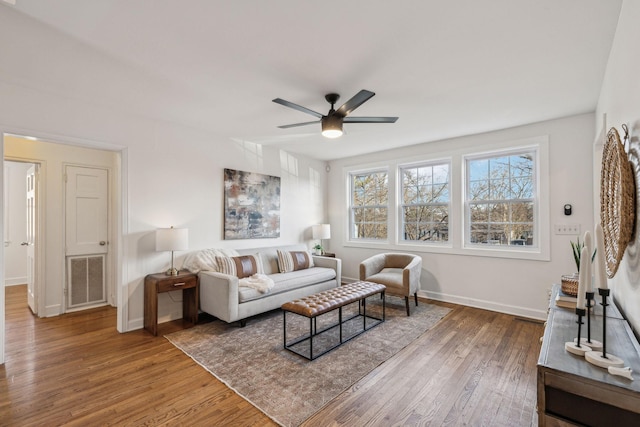 living room featuring visible vents, ceiling fan, baseboards, and wood finished floors