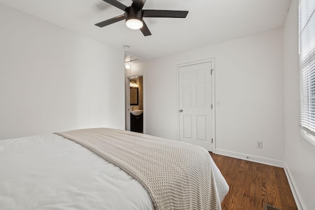 bedroom with attic access, multiple windows, baseboards, and wood finished floors