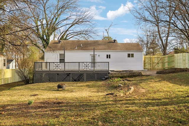 rear view of property with a fenced backyard, a lawn, and a wooden deck