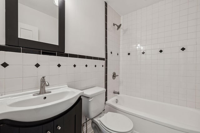 full bathroom with shower / bathing tub combination, vanity, toilet, and tile walls