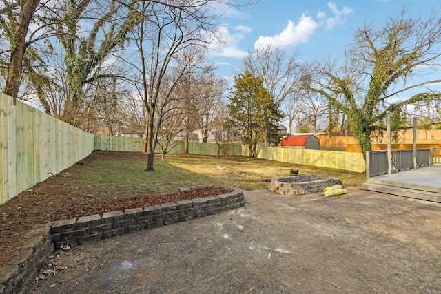 view of yard featuring a patio area, a fenced backyard, and a fire pit