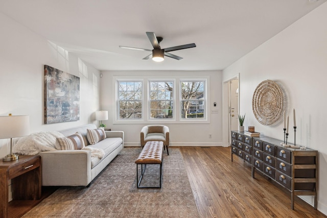 living area with ceiling fan, wood finished floors, and baseboards