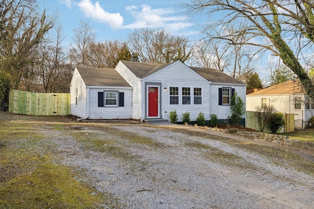 view of front facade featuring driveway, fence, and entry steps