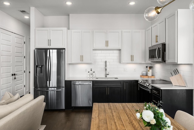 kitchen with a sink, visible vents, light countertops, appliances with stainless steel finishes, and tasteful backsplash