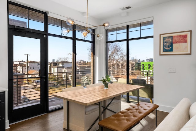 dining room with visible vents, dark wood finished floors, a notable chandelier, and baseboards