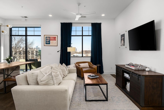 living area featuring a healthy amount of sunlight, baseboards, visible vents, and recessed lighting