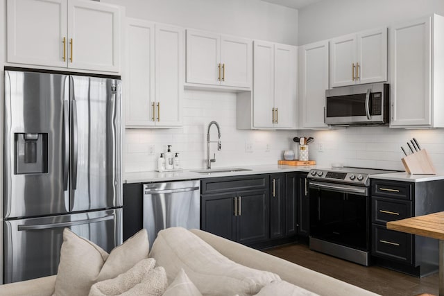 kitchen with stainless steel appliances, a sink, light countertops, and decorative backsplash