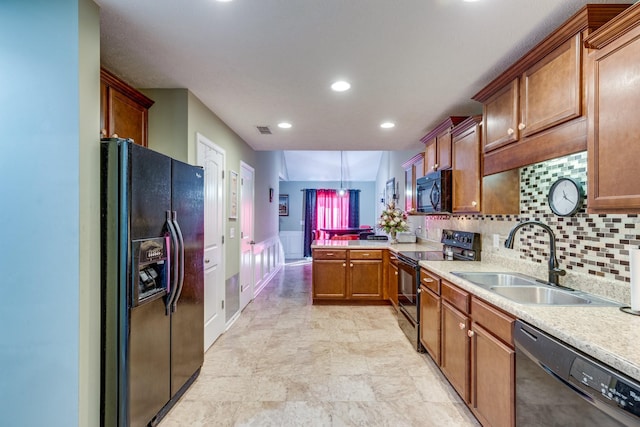 kitchen featuring visible vents, a peninsula, light countertops, black appliances, and a sink