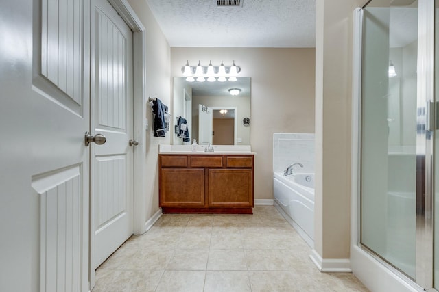 bathroom with a stall shower, tile patterned floors, a garden tub, a textured ceiling, and vanity