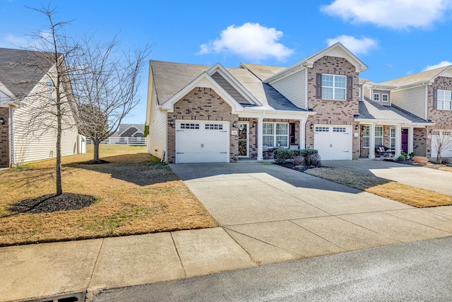 view of front of home featuring driveway, a garage, a front lawn, and brick siding