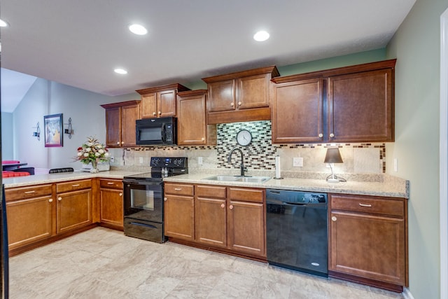 kitchen with black appliances, brown cabinetry, a sink, and decorative backsplash