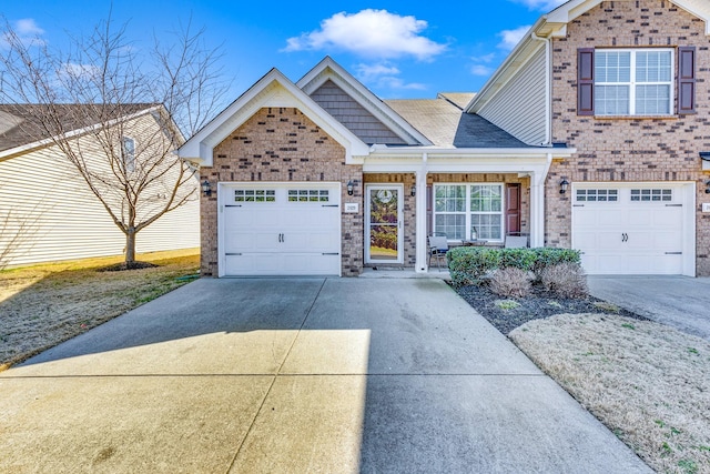 traditional home with a garage, driveway, and brick siding