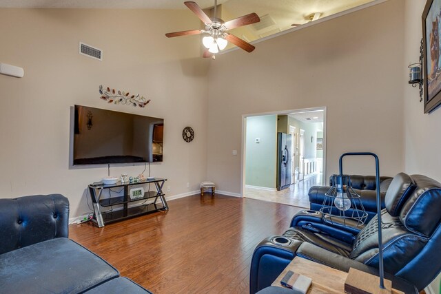 living room featuring visible vents, a ceiling fan, wood finished floors, high vaulted ceiling, and baseboards