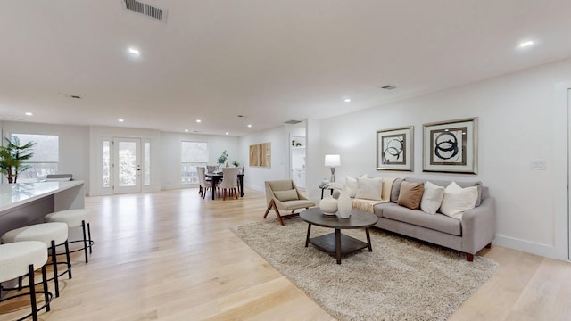 living area with recessed lighting, visible vents, and light wood-style flooring