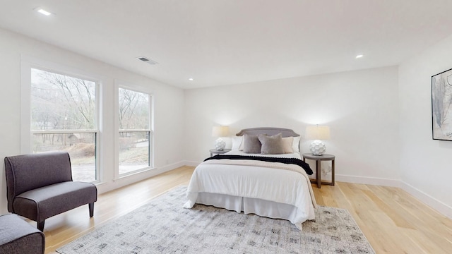 bedroom featuring recessed lighting, visible vents, light wood-style flooring, and baseboards