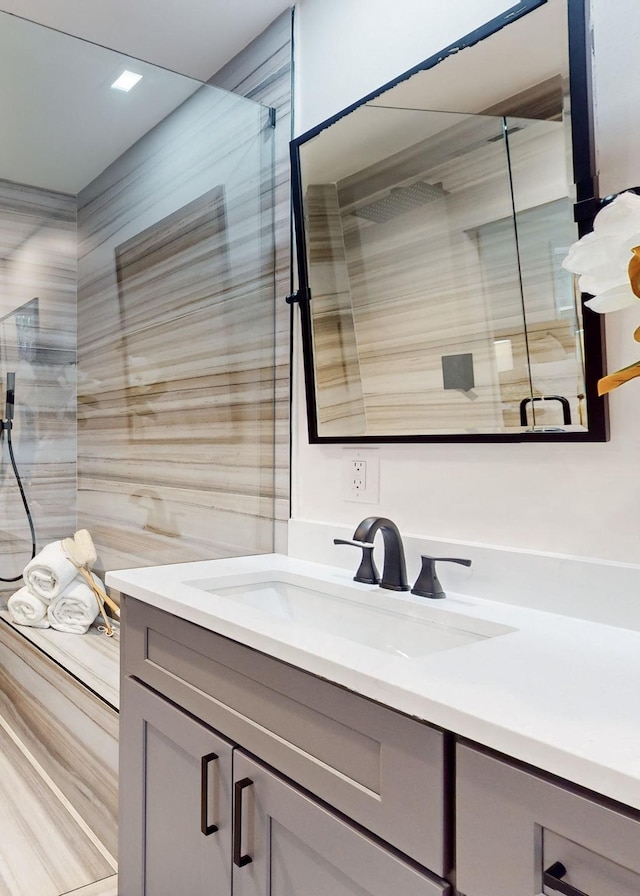 bathroom with a shower stall and vanity