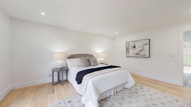 bedroom with baseboards, wood finished floors, and recessed lighting