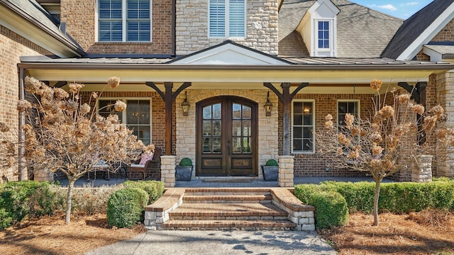 property entrance featuring metal roof, a porch, and a standing seam roof