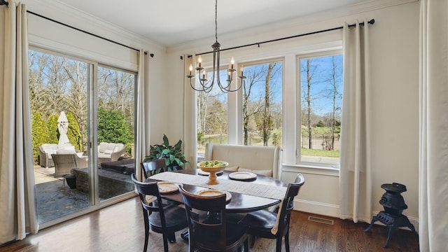 dining area with visible vents, baseboards, dark wood-type flooring, crown molding, and a notable chandelier