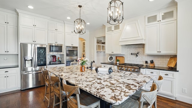 kitchen featuring stainless steel appliances, premium range hood, white cabinets, dark wood-style floors, and glass insert cabinets