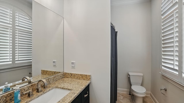 bathroom with toilet, vanity, baseboards, ornamental molding, and tile patterned floors