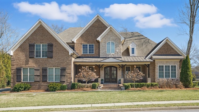 craftsman house featuring metal roof, brick siding, a standing seam roof, and a front yard