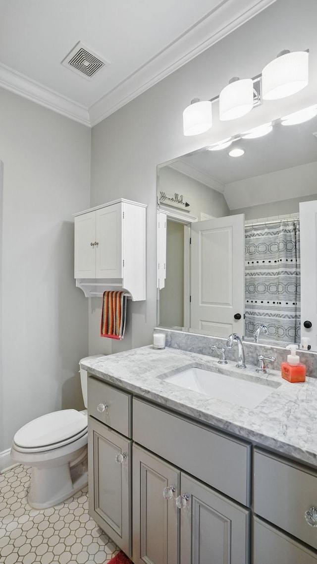 bathroom featuring toilet, vanity, baseboards, visible vents, and crown molding