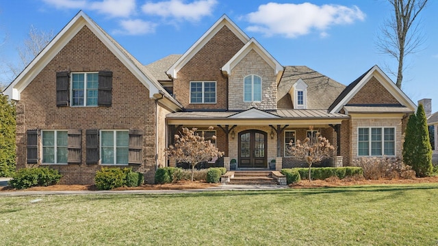 view of front facade featuring a standing seam roof, a front lawn, and brick siding