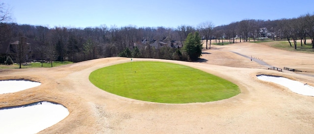 view of community with golf course view and a wooded view