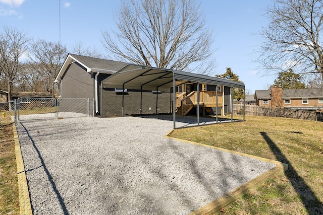 exterior space featuring driveway, a gate, fence, and a detached carport